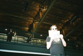 Andrew Paul Nelson reads in the atrium at Pier 70 with musical accompaniment from Nick Jaina